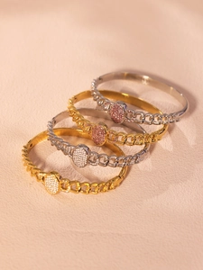Detail of gold and silver NK chain bracelets with oval pave zirconia in pink and white