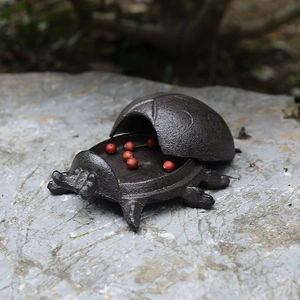 Vintage cast iron ladybug key box decorative rustic container on stone surface
