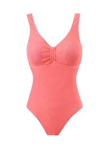 Détail du tissu seersucker rose corail et plissé du col en V sur le maillot de bain
