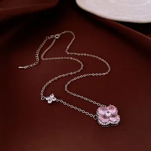 Collier trèfle argenté avec zircons roses en forme de cœur sur tissu en soie rouge