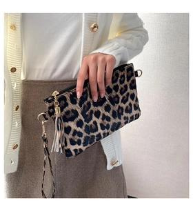 Detailed close-up of leopard print clutch bag with gold hardware and tassel detail