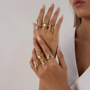 Close-up of stacked 18K gold and silver stainless steel rings with white zircon stones