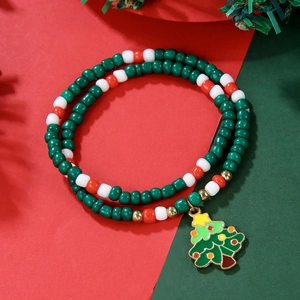 Christmas beaded bracelet with red, green, and white beads and a Christmas tree charm
