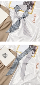 Detail of light blue silk scarf featuring checkered pattern and artistic illustrations