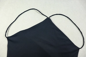 Detail of elegant black backless dress showing thin straps and high-quality woven fabric