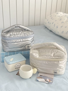 Quilted waterproof cosmetic bags in silver and cream colors with Soda Blue label