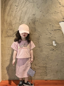 Detail of a young girl wearing a stylish pink outfit with a shiny silver rhinestone purse