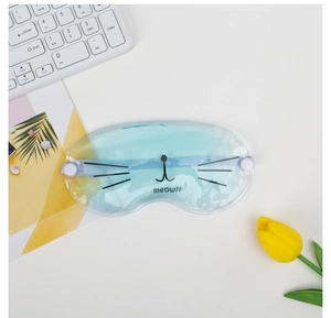 Detail of blue cooling cat eye mask with meow design on desk with keyboard