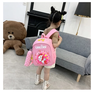 Pink unicorn backpack for kids with a matching pencil case shown in a lifestyle scene