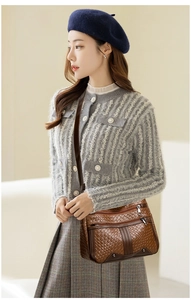 Detail of soft brown leather crossbody bag featuring a vintage woven texture pattern