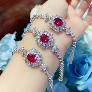 Bracciale a girasole con tormalina rossa e zirconi su uno sfondo floreale blu chic