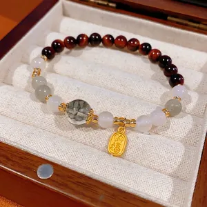 Green phantom crystal and red tiger eye beaded bracelet with gold blessing pendant