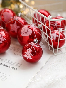 Close-up of red Christmas ball ornaments with white flocked star and heart patterns