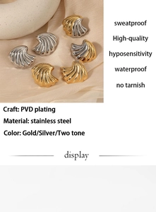 Detailed view of shell-shaped stainless steel earrings with gold and silver PVD plating