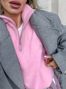 Detail showing pink fleece half-zip sweatshirt layered with a grey wool coat for autumn