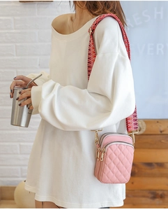 Pink quilted nylon crossbody bag with bohemian wide strap shown in a lifestyle setting