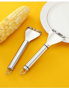 Dual stainless steel corn peelers with hanging loops on a vibrant yellow background