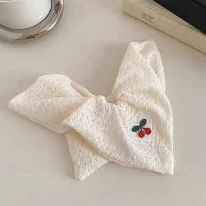 Detailed view of white lace bow hair scrunchie with delicate cherry embroidery and texture