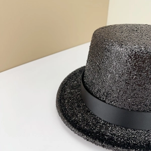 Gros plan sur la texture tissée et le ruban côtelé noir d'un chapeau haut-de-forme vintage