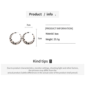 Detailed view of 7cm cow print iron hoop earrings with dimensions and weight specs