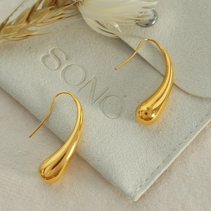 Elegant gold teardrop hook earrings with mirror polish finish on a soft velvet pouch