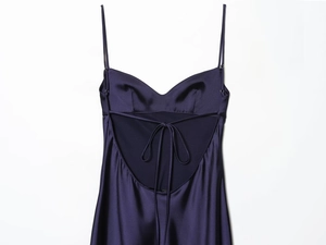 Détail d'une robe en satin bleu marine avec dos nu et fines bretelles croisées