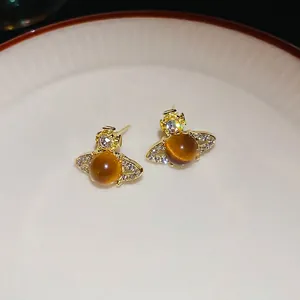 Elegant gold-plated planet stud earrings featuring a brown gem and sparkling crystal accents