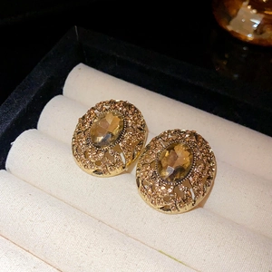 Macro shot of vintage gold earrings with amber faceted stone in a jewelry box