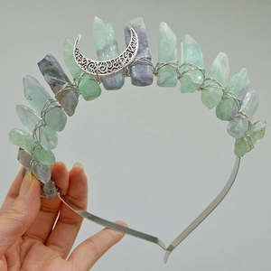 Macro view of crystal crown featuring green fluorite stones and a silver crescent moon