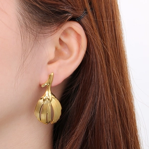 Close-up of vintage gold leaf earrings featuring detailed metallic plant textures