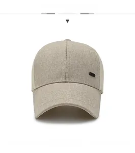 Detail view of a beige breathable mesh baseball cap with side metal emblem decoration