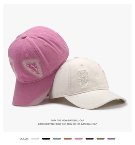 Detailed view showing distressed texture on pink and cream washed cotton baseball caps