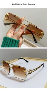 Detail of gold metal panther relief and gradient brown lenses on rimless sunglasses
