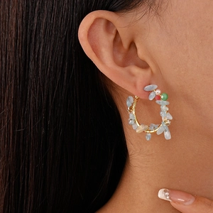 Vue détaillée de boucles d'oreilles créoles avec pierres multicolores sur le mannequin
