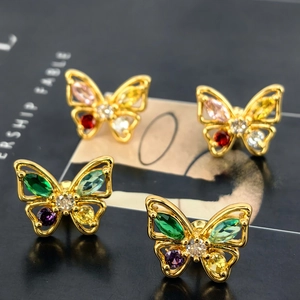 Macro detail of butterfly stud earrings featuring colorful cubic zirconia on gold base