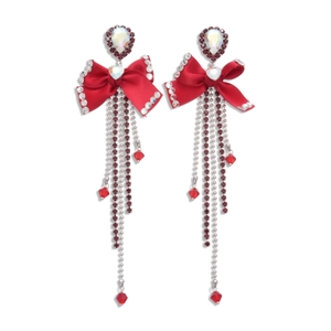 Exaggerated red rhinestone bow earrings with tassels for women in studio lighting