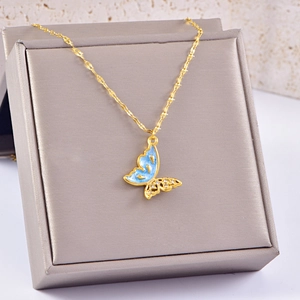Collana a farfalla dorata con smalto celeste e zirconi scintillanti su portagioie
