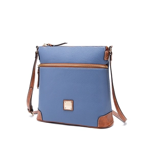 Detail of lychee textured crossbody bag with blue brown leather and gold hardware