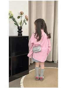 Rear view of child wearing a silver quilted star crossbody bag with chain strap