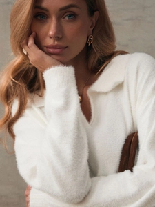 Detail of soft white mohair knit sweater featuring a stylish V-neck polo collar and fuzzy texture