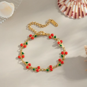 Golden stainless steel cherry charm bracelet with red enamel fruit and green leaf pendants