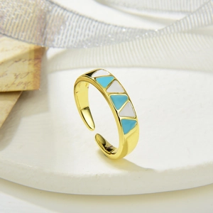 Detailopname van gouden verstelbare ring met blauwe en witte driehoeken van emaille lak