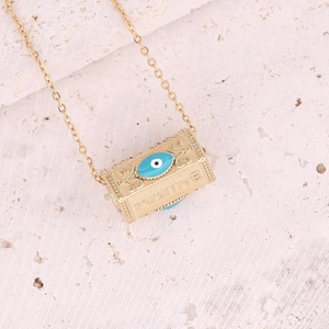Macro shot of gold cylinder pendant with blue evil eye and Positive engraving