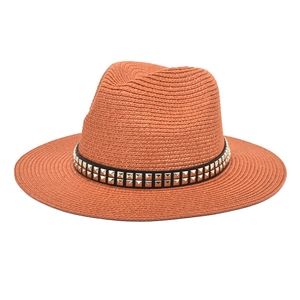 Detail of caramel straw fedora hat featuring a black leather band with silver metal studs