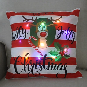 Close-up of LED Christmas pillow with glowing reindeer pattern and red stripes