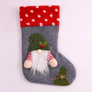Détail d'une chaussette de Noël en feutre gris avec motif de gnome et revers rouge