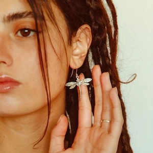 Orecchini a forma di libellula vintage in argento con gemma blu indossati da modella