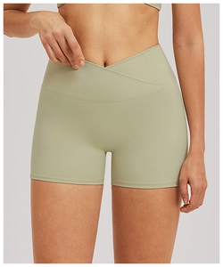 Detail view of the V-shaped cross waistband on sage green high-stretch yoga shorts