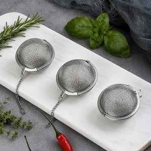 Three-piece stainless steel spice infuser ball set with fine mesh on marble tray