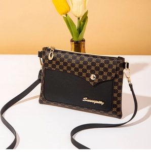 Detailed shot of the black and brown patterned crossbody bag with elegant gold hardware